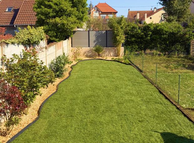 Jardin rectangulaire, plutôt long que large, pris en photo depuis l’arrière de la maison en regardant vers le fond du terrain.